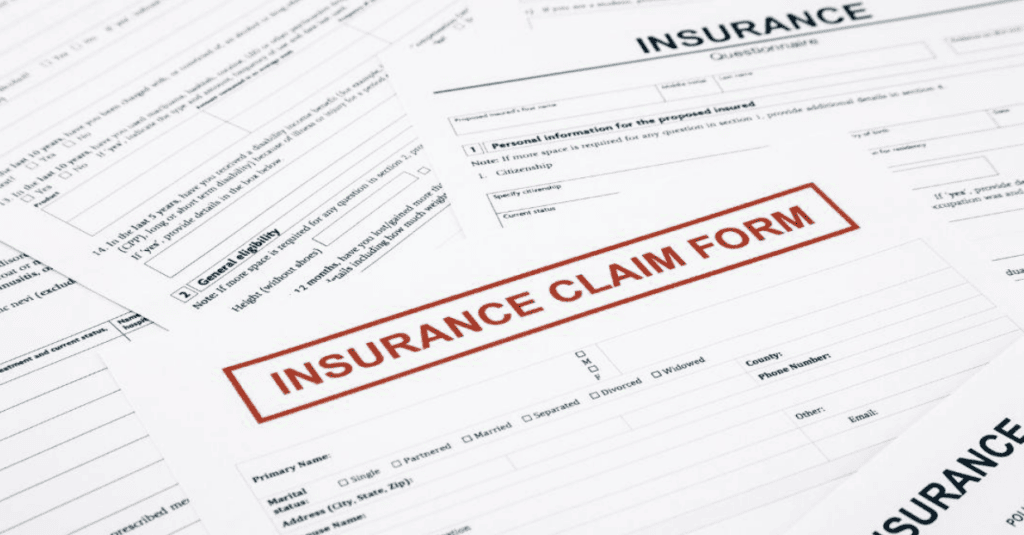 Several insurance forms are spread out on a surface, with a prominent Insurance Claim Form in the center, featuring bold red text.